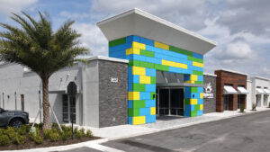 colorful blue yellow and green entry to amazing explorers academy coming soon to woodlands texas by kimaya park square homes
